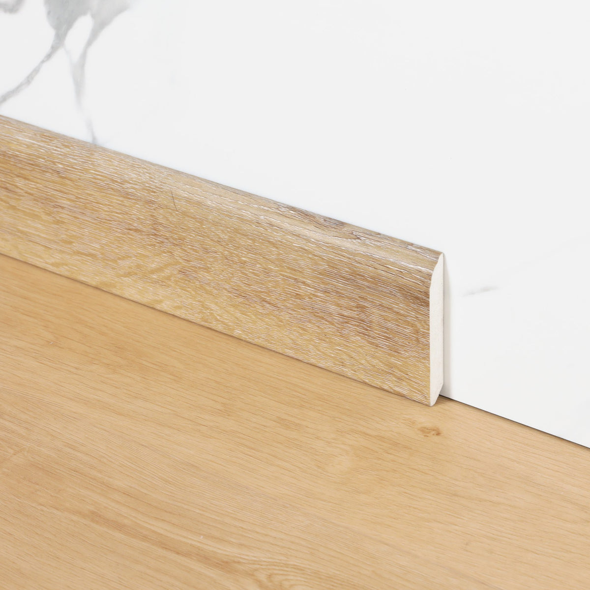 Plinthe assortie FloorEver 2 200 × 80 × 12 mm, revêtue du décor de la lame, au pied du mur